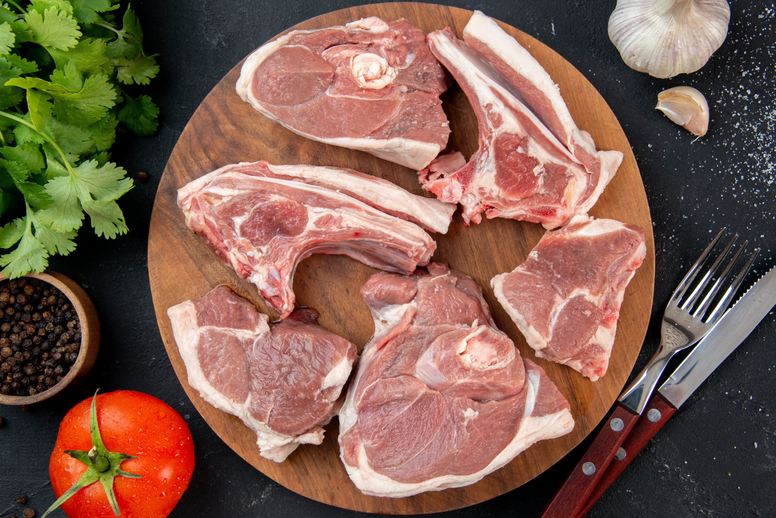 top-view-fresh-meat-slices-raw-meat-with-greens-tomatoes-dark-kitchen-meal-food-cow-food-dish-salad-barbecue-animal